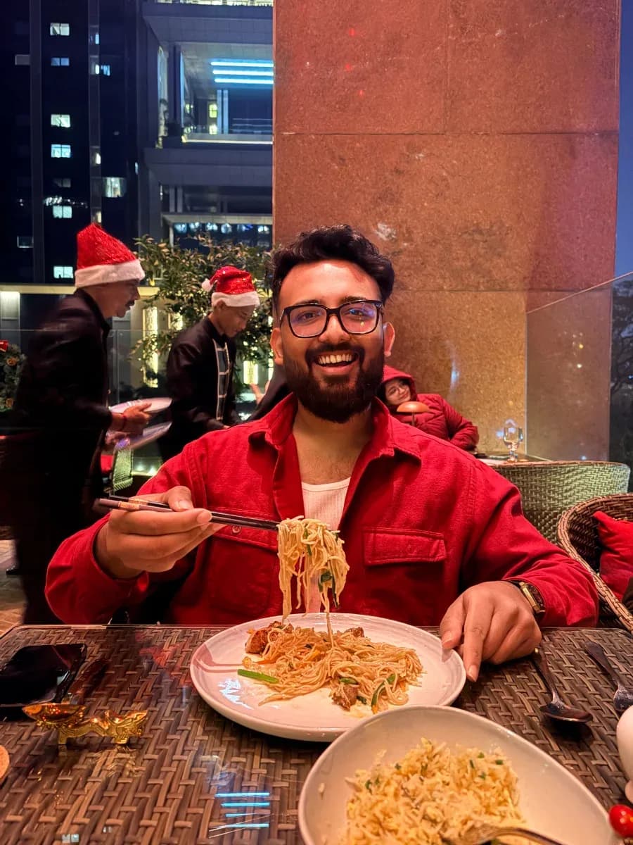 The cook at the table, mid-noodle